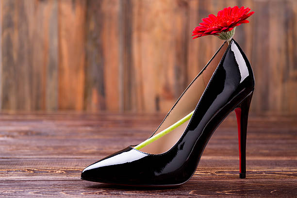istock Red flower on black shoe. 628024460