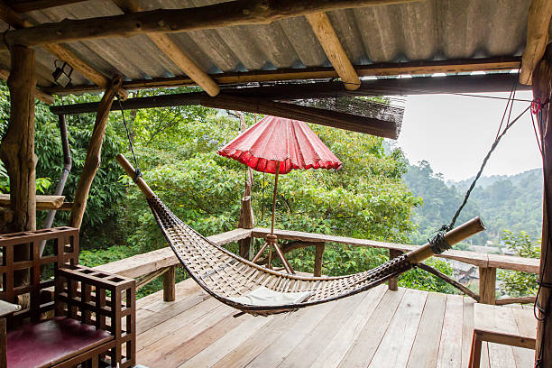 istock Empty wooden hammock outside the terrace with jungle background 628030754