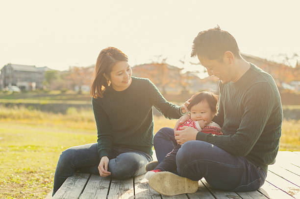 女の赤ちゃんと楽しい時間を過ごしている幸せな家族 - 太陽の光 写真 ストックフォトと画像