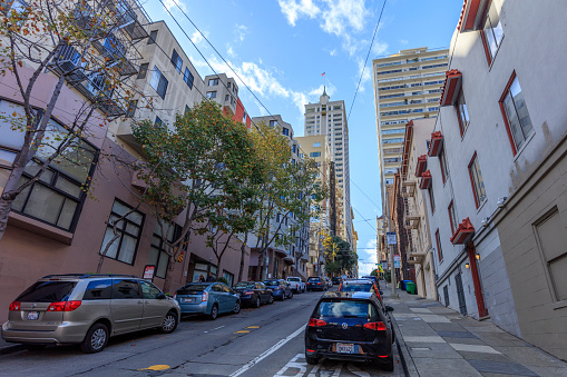 San Francisco, CA, USA - November 23, 2016:   San Francisco downtown street view. Residential and business buildings on the roadside. Incidental people on the background.
