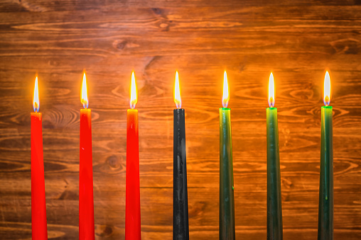 Kwanzaa festival concept with seven candles red, black and green on wooden background, close up