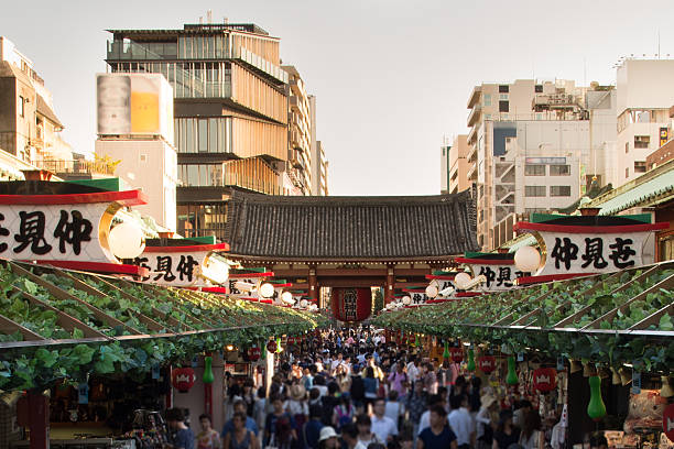 Bustling Tokyo Shopping Street Nakamise Shopping Street in Tokyo, with the Kaminarimon gate in the background sensoji stock pictures, royalty-free photos & images