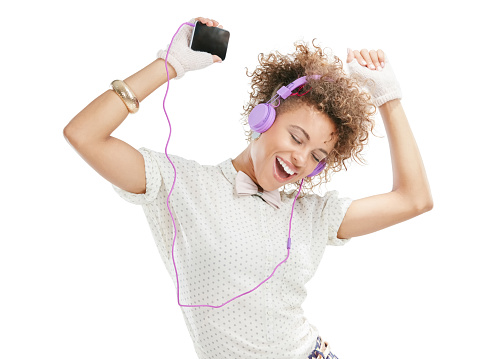 Studio shot of an attractive young woman listening to music on her phone against a white background