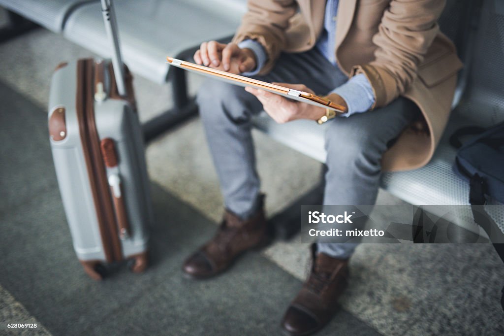 L'uomo usa il tablet digitale nell'aeroporto lounge - Foto stock royalty-free di Viaggio di lavoro