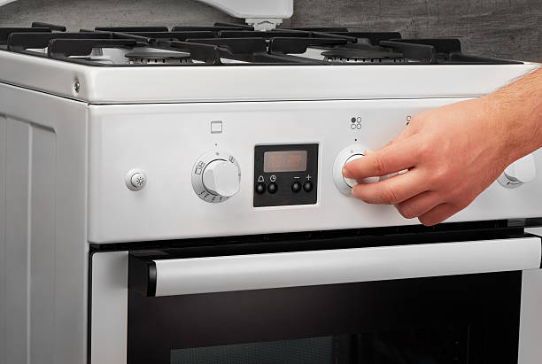 istock Male hand turning on white kitchen gas stove on gray 628084656