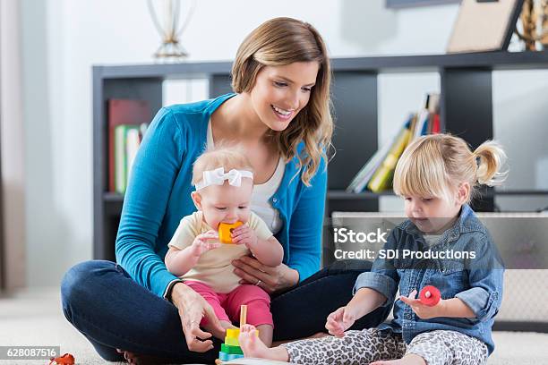 Mamá O Niñera Juega Con Niños En Casa Foto de stock y más banco de imágenes de Niñera - Niñera, Niño, Adulto