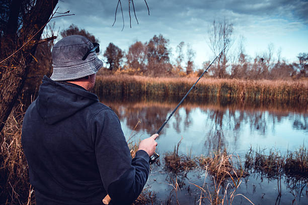istock Young man fishing on river at winter 628087528