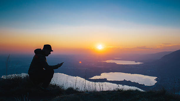 istock Hiker checks smartphone over mountain during sunset 628089492