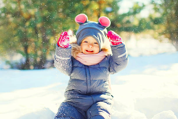 istock Winter happy smiling child playing with snow 628091270