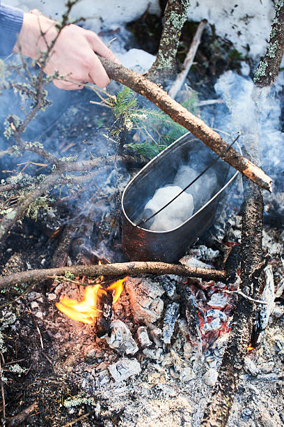 istock Hand melts the snow on the fire in a saucepan 628095728