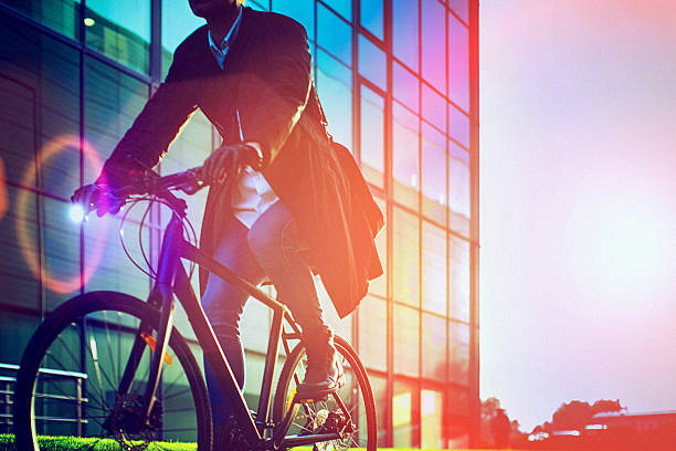 Handsome man riding bicycle beside the modern office building stock photo