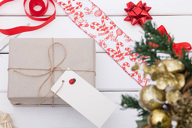 istock Christmas gift box on blank tag on wood table 628096710