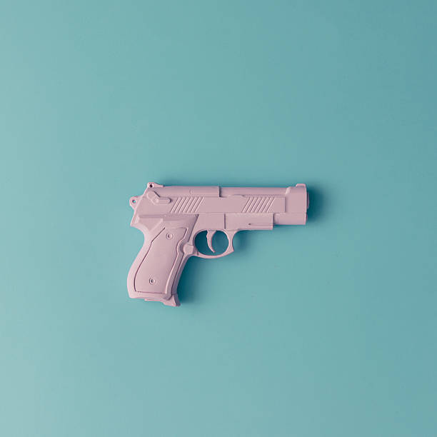 istock Pink hipster handgun on blue pastel background. Minimal flat lay 628097084