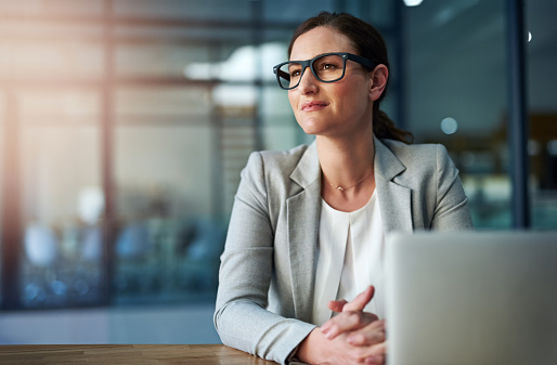 Shot of an attractive businesswoman using her laptop while sitting at her desk