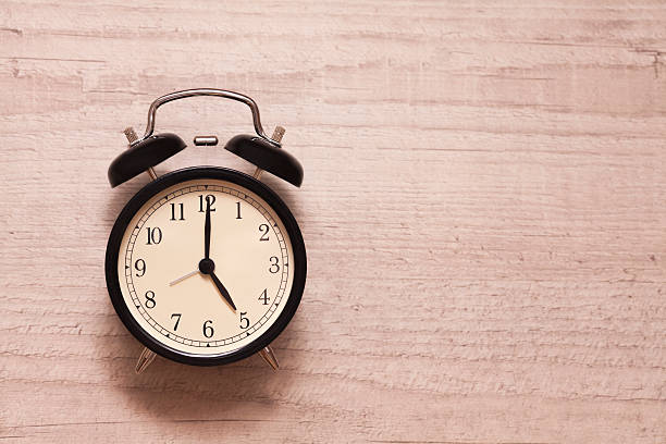 alarm clock showing five o'clock on wooden background - 5 horas imagens e fotografias de stock