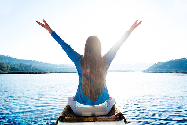 istock Woman Meditating On A Calm Lake 628102144