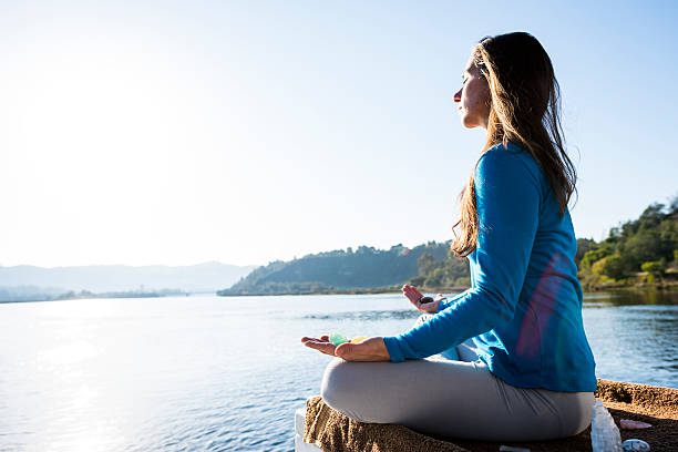 Woman Meditating On A Calm Lake