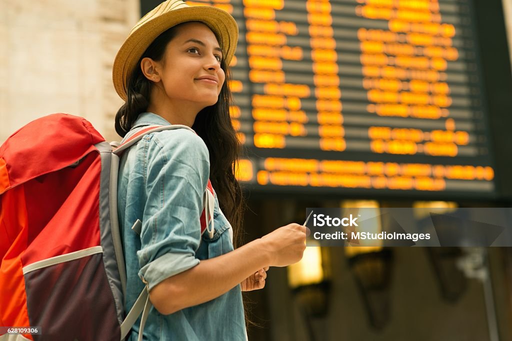 Junge Frau überprüft ihren Zug in Zeittafel - Lizenzfrei Flughafen Stock-Foto