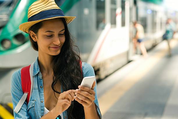 istock Smiling woman using smartphone at the subway station. 628109424