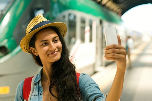 Young woman taking selfie before departure.