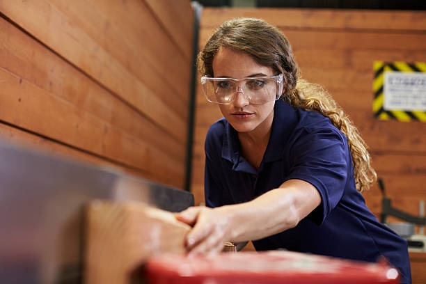 istock Female Carpenter Using Plane In Woodworking Woodshop 628110784