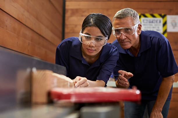 Carpenter Training Female Apprentice To Use Plane Carpenter Training Female Apprentice To Use Plane plane hand tool photos stock pictures, royalty-free photos & images