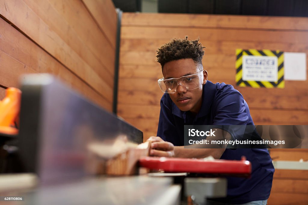Carpenter Using Plane In Woodworking Woodshop Teenager Stock Photo
