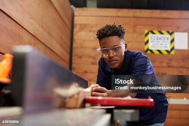 Carpenter Using Plane In Woodworking Woodshop Stock Photo - Download Image Now - Teenager, Occupation, Working