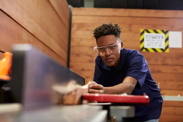 Photo of Carpenter Using Plane In Woodworking Woodshop