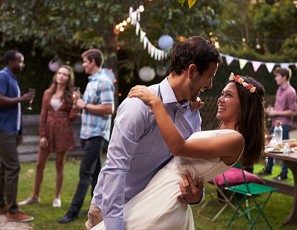 istock Young Couple Celebrating Wedding With Party In Backyard 628111818