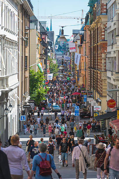 Stockholm crowds of pedestrians on Drottningaten central shopping street Sweden Crowds of locals and tourists strolling along the pedestrianised shopping street of Drottningaten in the city centre of Stockholm, Sweden's vibrant capital city. stockholm town square sergels torg sweden stock pictures, royalty-free photos & images