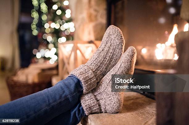 Feet Of Unrecognizable Woman In Socks By The Christmas Fireplace Stock Photo - Download Image Now