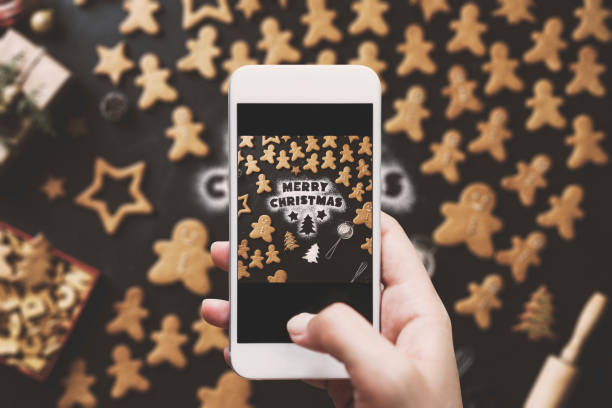 istock Hand photographing, Christmas gingerbread men cookies table top 628120150