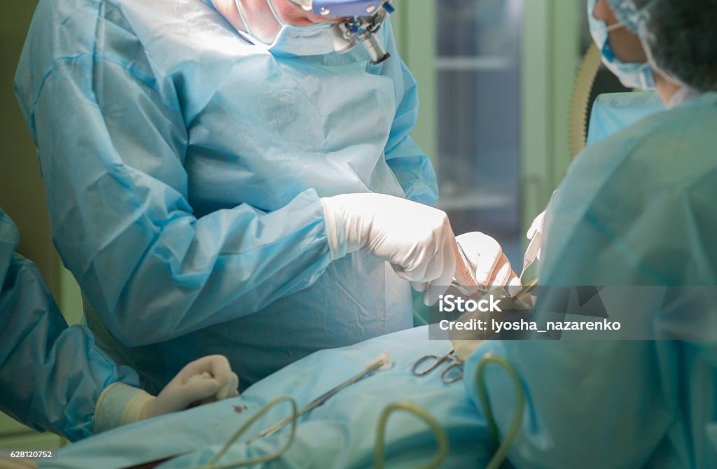 Cirujano en el trabajo. Cirugía en quirófano hospitalario - Foto de stock de Cirugía libre de derechos