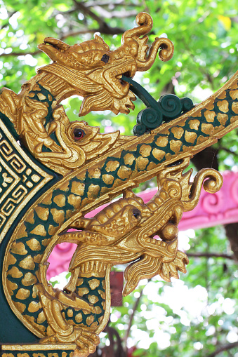 golden green dragon holding ball and flushing holy water statue in Thai temple 
