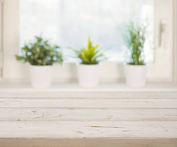 istock Wooden table on blurred winter window with plant pots background 628122654