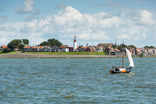 Urk, Netherlands - August 10, 2016: Sailing boat sailing in front of the Urk fishers village , Urk was an island until 1939 in the zuiderzee where the fish was caught