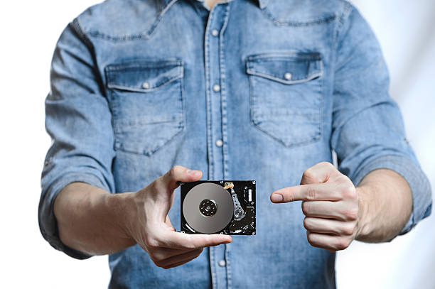 istock Man's hand holds a 2.5 inch hard drive 628125700