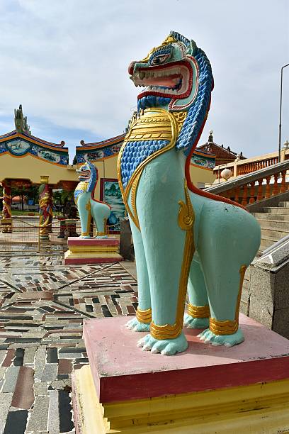 istock Two Stone Singha statue painted green standing in front stairs 628127986