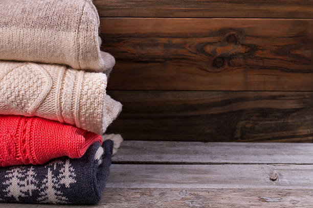 istock Beautiful knitted sweaters on vintage wooden background. 628135094