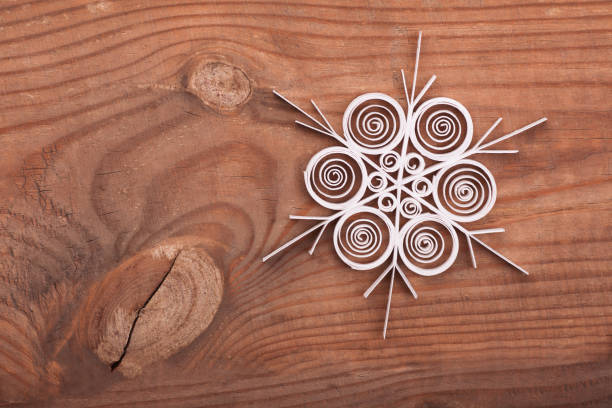 istock Paper snowflake made with quilling technique on a wooden surface 628135894