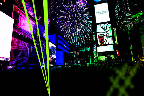 Laser beams and fireworks in Times Square, New York City. Laser beams and fireworks in Times Square, New York City for New Year's Eve party. NOTE: Since there are many varied advertisements, none of which are the focus of the image, this upload does not need to be editorial according to the iStock guidelines. times square new years eve stock pictures, royalty-free photos & images