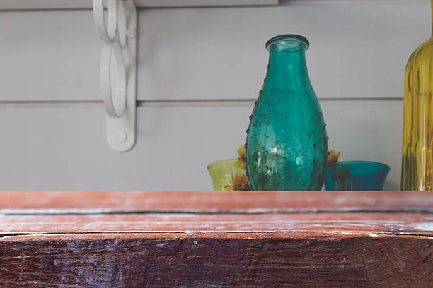 wood table for montage or display your product with blur background of vintage retro glass bottle decorating on shelf on white wall