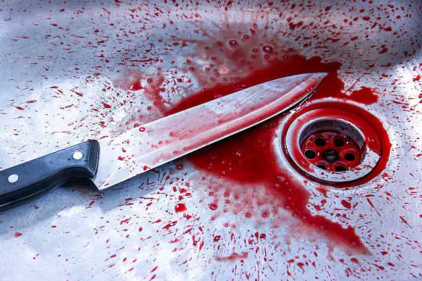 Photo of Concept image of a sharp knife with blood in sink