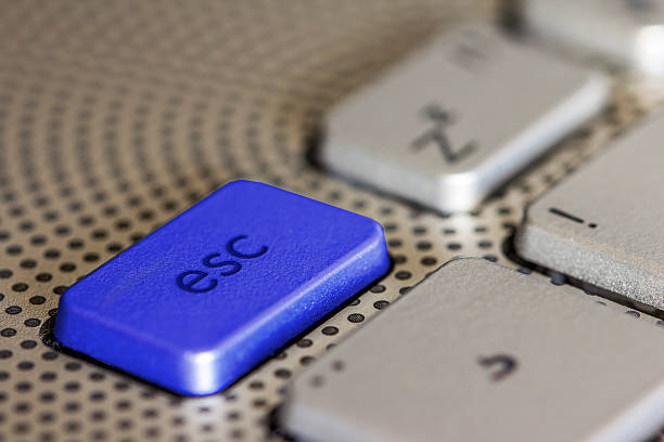 Esc key on computer keyboard Esc key on silver computer keyboard in blue. Escape. escape key escape computer push button stock pictures, royalty-free photos & images