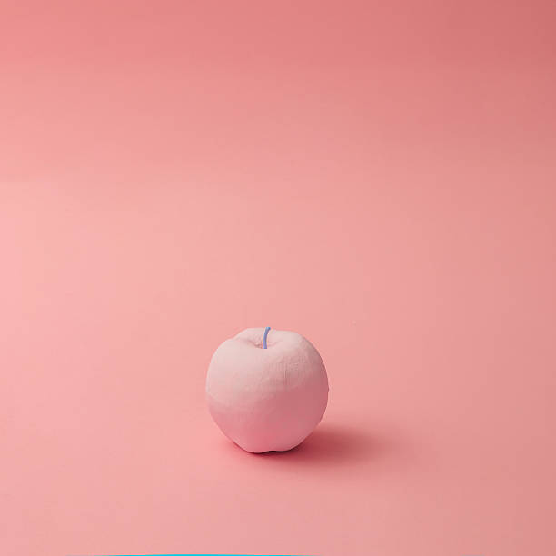 istock Pink apple on pink background. Minimal style. Food concept. 628155722