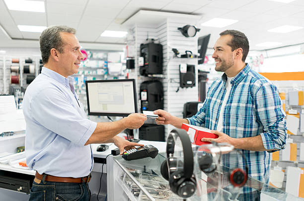 hombre comprando en una tienda de tecnología - tienda de electrónica fotografías e imágenes de stock