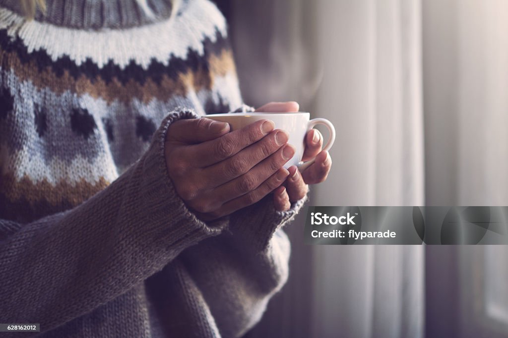 Mujer en las manos del suéter de punto sosteniendo la taza de café caliente - Foto de stock de Invierno libre de derechos