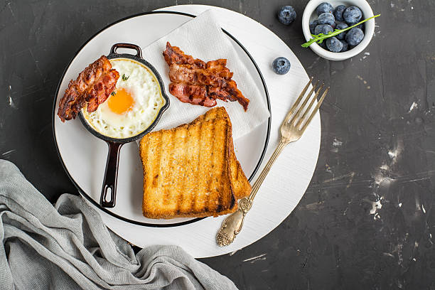istock Breakfast set. Pan of fried eggs with bacon and fresh 628162896