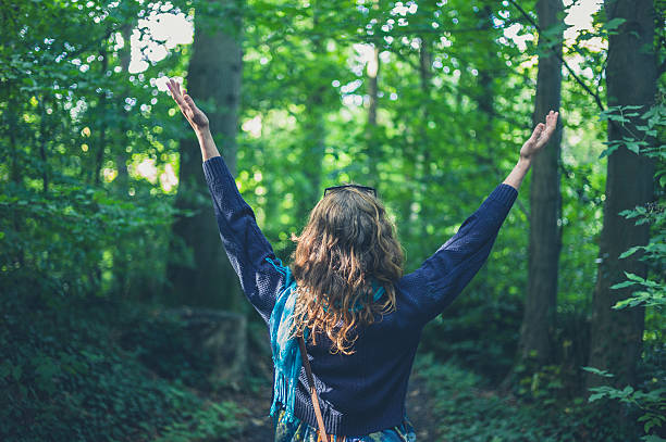 istock Woman raising her arms in the forest 628164282